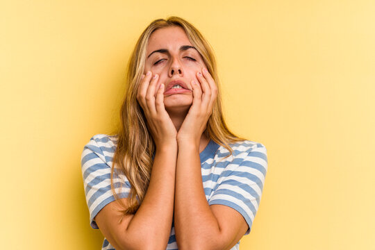 Young caucasian blonde woman isolated on yellow background  whining and crying disconsolately.