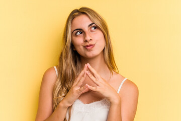 Naklejka premium Young caucasian blonde woman isolated on yellow background making up plan in mind, setting up an idea.