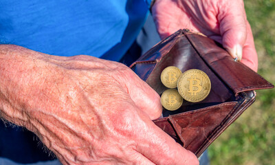 Old man holds wallet with bitcoins