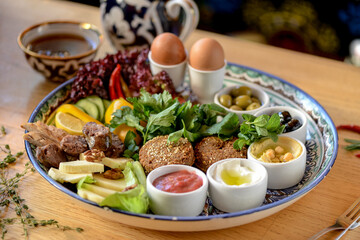 large oriental breakfast on a large plate on the table with tea on the background
