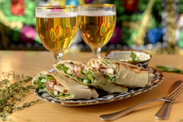 shawarma sliced ​​on a plate on a background with two glasses of beer
