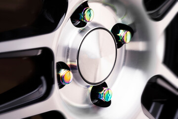 wheel nuts for alloy wheel yellow or green, iridescent close-up on an aluminum disc