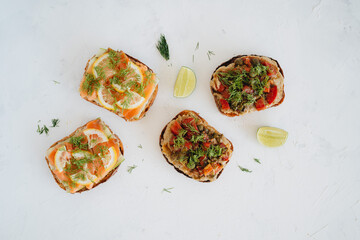 Salmon and eggplant toasts on a plate on white background