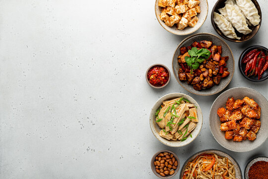 chinese food, chinese traditional cuisine dishes on a light concrete background, top view, copy space
