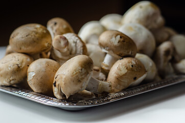 Portobello and white mushrooms on a silver plate, vegetables from an organic farm