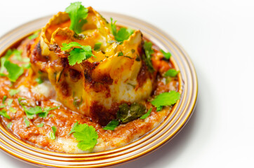 Hand rolled four cheese ravioli pasta in minced beef with Chianti red wine, garlic and herb ragu, and a bechamel sauce topped with pecorino cheese crumb and finished with fresh parsley