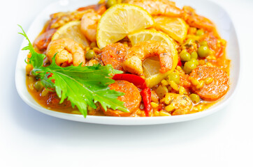 Delicious paella, cooked risotto rice with chicken thigh, king prawns, tomatoes and  chorizo