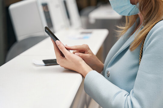 Female tourist employing her smartphone at airport terminal