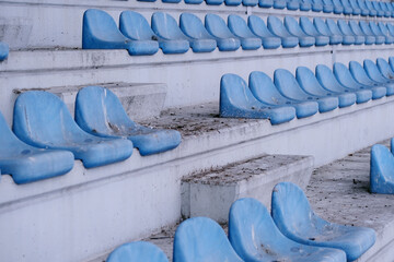 Row of abandoned stadium bleachers seats covered in pigeon droppings

