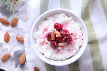 Christmas rice pudding with almonds and cherries on a light background. Risalamande