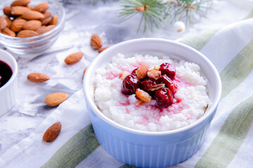 Christmas rice pudding with almonds and cherries on a light background. Risalamande