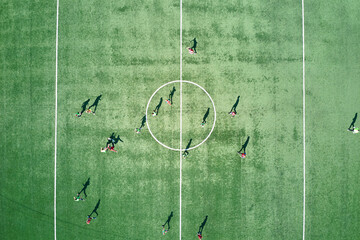 Aerial view of soccer players playing football on green sports stadium © bilanol