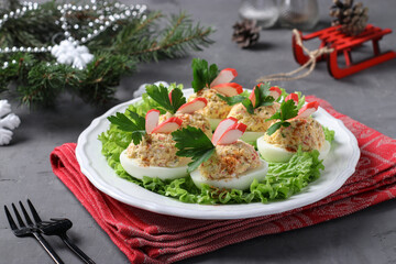 Stuffed eggs with crab sticks and cheese, a delicious festive snack on dark background. Closeup