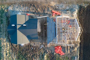 Aerial view of unfinished frame of private house with aerated lightweight concrete walls and wooden roof frame under construction
