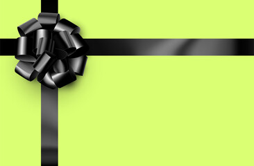 Beautiful foil black bow with ribbon on green background.