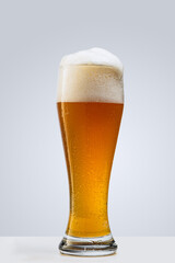 Glass of lager foamy beer isolated over gray background. Concept of alcohol drinks