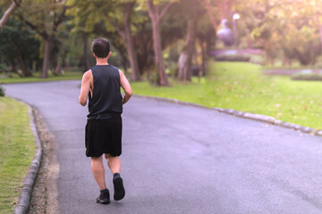 Obraz premium Back view of senior man jogging in the park.
