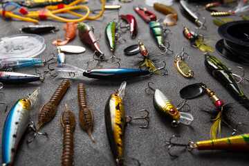 Fishing tackle - fishing spinning rod, hooks and lures on gray background. Active hobby recreation...