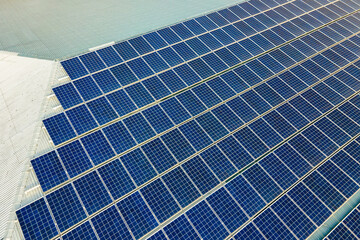 Closeup of surface of blue photovoltaic solar panels mounted on building roof for producing clean ecological electricity. Production of renewable energy concept