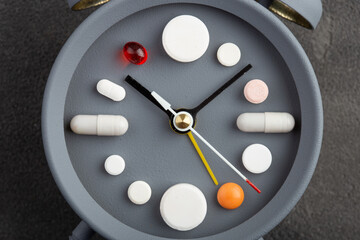 Creative healthcare and medicine concept - clock with drugs and pills.Right time for using...