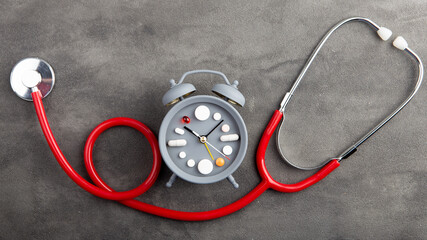 Take medicine on time! Creative healthcare and medicine concept - clock with drugs and pills. Cold and flu season. Period of diseases.