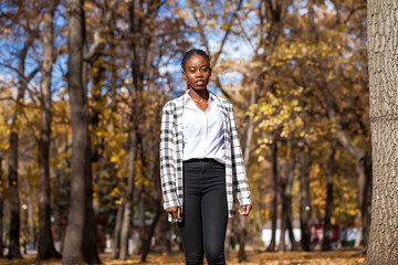 Young beautiful brunette woman posing in autumn park