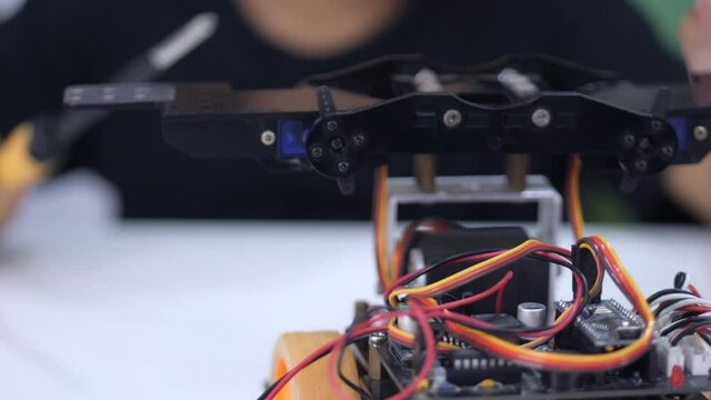 Slow motion scene of 4-5 year old Asian girl is assembling a robot and playing with an automated robot.