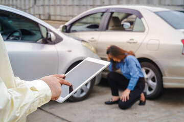 Fototapeta na wymiar insurance company employee Saving insurance claim information on the tablet. The woman was sad that the car was hit. car insurance concept
