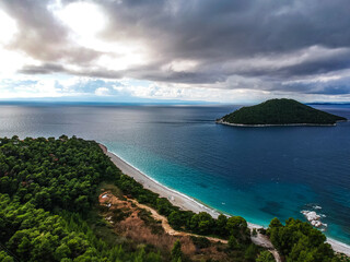 Aerial panoramic view over Milia beach in Skopelos island, against a cloudy sky in Sporades, Greece