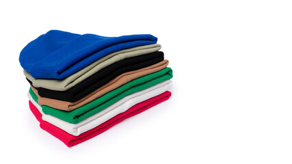 Stack of insulated stylish beanie hats in bright colors isolated on white with copy space.