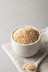 A pile of psyllium husks in a bowl on the table. Dietary supplement, superfood. Copy space