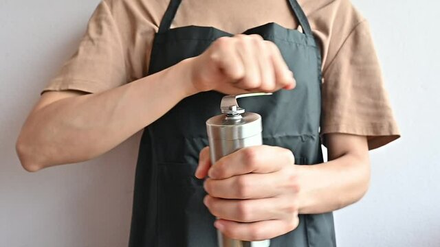 Footage video of female barista using manual coffee grinder for crushes the coffee beans into a uniform size which is essential for creating an awesome espresso.