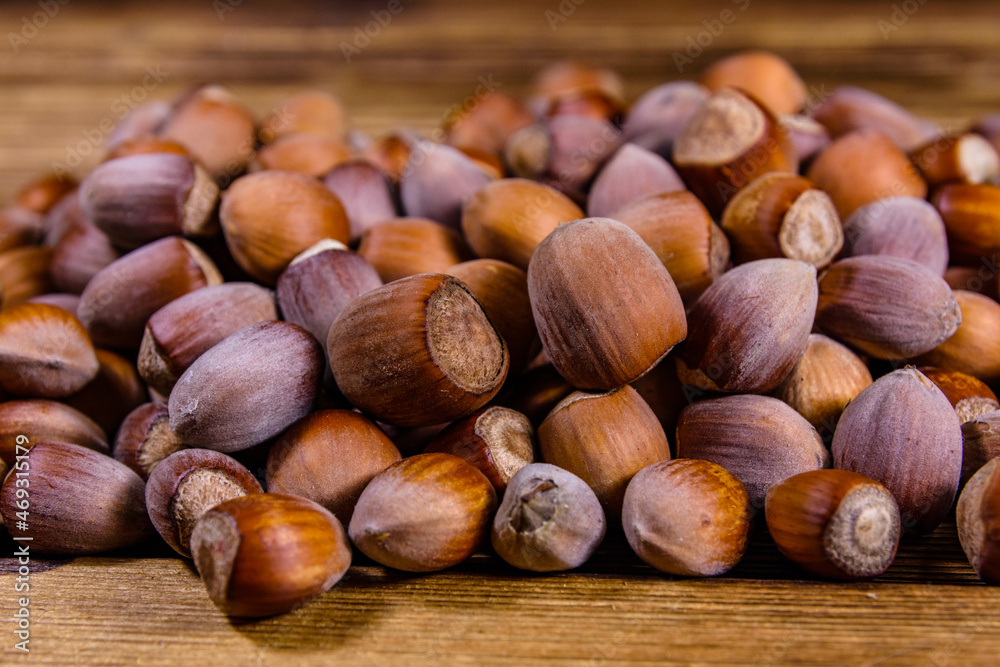 Wall mural Pile of the hazelnuts on wooden table - Wall murals