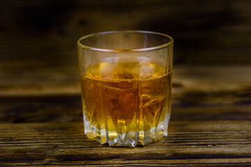 Glass of whiskey on the dark wooden background