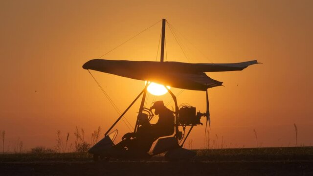 The preparing for testing flight by hang glider on beautiful sunset background