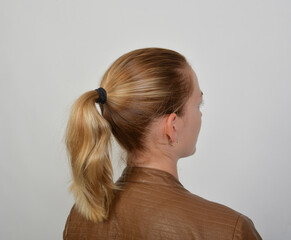 frau frisur dunkelblond haare bruenett zopf haargummi piercing ohrenschmuck ohrstecker © fotoak80