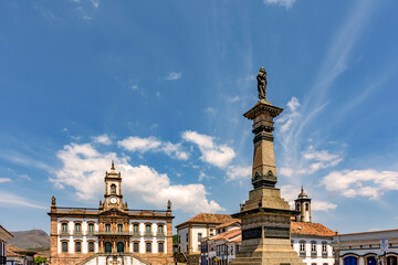 Fototapeta na wymiar Central square in the historic city of Ouro Preto in Minas Gerais with its houses, churches and monuments on a sunny day