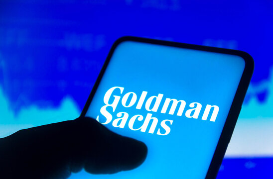 November 15, 2021, Brazil. In this photo illustration the Goldman Sachs Group logo displayed on a smartphone screen and a stock market graph in the background.