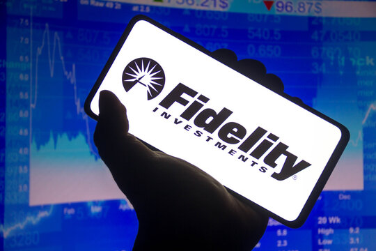 November 15, 2021, Brazil. In This Photo Illustration The Fidelity Investments Logo Displayed On A Smartphone Screen And A Stock Market Graph In The Background.