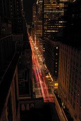 A photograph of a Manhattan street at night using a slow shutter speed taken from the 18th floor of a hotel