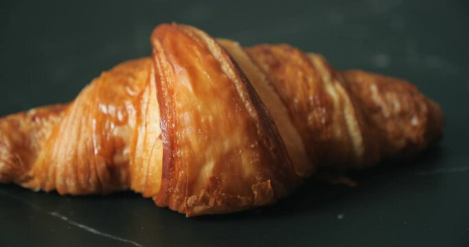 Fresh a croissant on black stone table background.