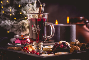 Mulled wine with cranberry and spices, Christmas cookies and candles