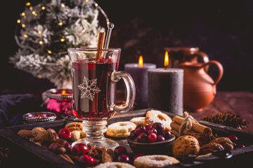 Mulled wine with cranberry and spices, Christmas cookies and candles