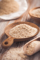 Isabgol - heap of psyllium husk in wooden bowl on wooden table table