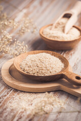 Isabgol - heap of psyllium husk in wooden bowl on wooden table table