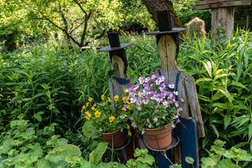 hölzerne Dekoration mit blühenden Pflanzen in sommerlichem Garten