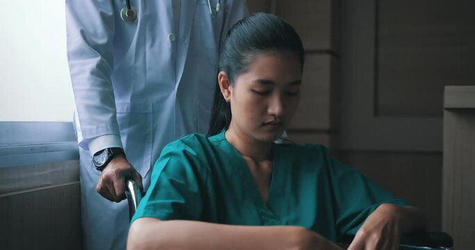 Asian woman are concerned about the disease  they themselves have and she sits on wheelchair with a doctor 