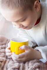 A little boy with a cup of tea, the aroma of a drink