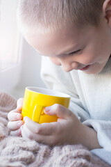 A little boy with a cup of tea, the aroma of a drink