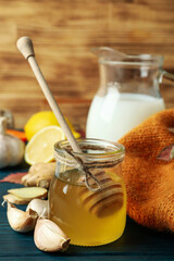 Concept of treatment colds with honey and garlic on  wooden background